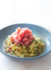 Tuna and pineapple Brazilian ceviche on a white surface and blue dish