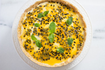 Paasion fruit cheesecake on a cute ceramic on a marble surface top view