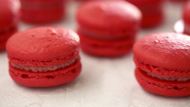 Close-up view of many rows of red macarons macaroon on white background. Classical French dessert.