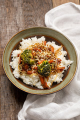 Thai style rice with fried vegetables and soy sauce on wooden background