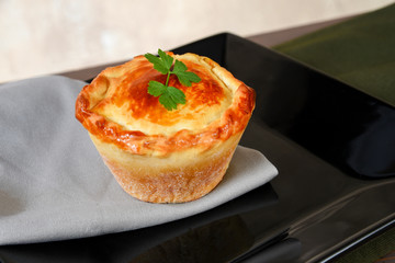 baked pie stuffed with chicken, shrimp, meat on the table, isolated on blurred background. typical Brazilian food empadinha