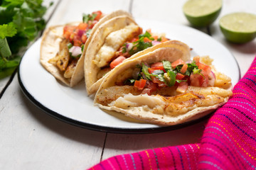 Mexican fish tacos also called Baja with fresh sauce on white background