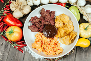 Assorted chips with sauce on a white plate