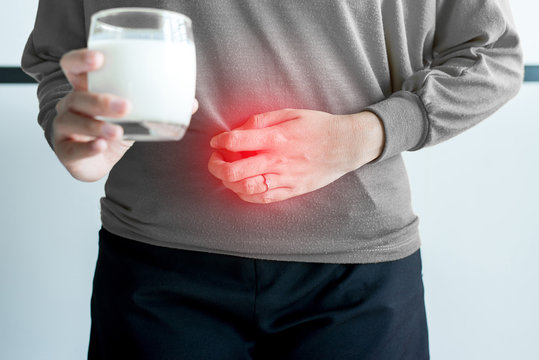 Allergy dairy intolerant,Lactose intolerance concept,Asian woman having a stomach pain with a glass of milk