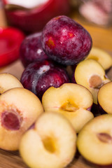 Plum Fresh and sliced on a wood spoon