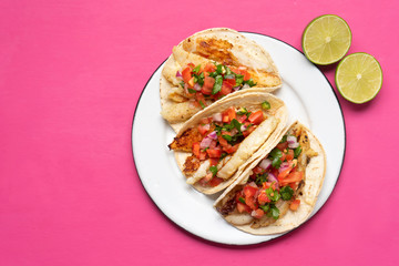 Mexican fish tacos also called Baja with fresh sauce on pink background