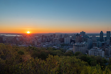 Fototapeta na wymiar Beautiful sunset over Montreal's skyline viewed from the Kondiaronk belvedere in the Mont-Royal park