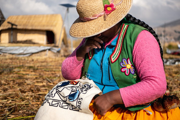 The Uros community showing off their handcrafts while tourists visit their floating island made of...