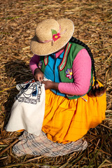 The Uros community showing off their handcrafts while tourists visit their floating island made of...