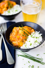 Curry chicken on black bowls and beer