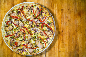 Pizza with red pepper on a wooden table