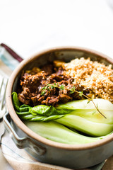 Beef stew with bok choy on a marble surface