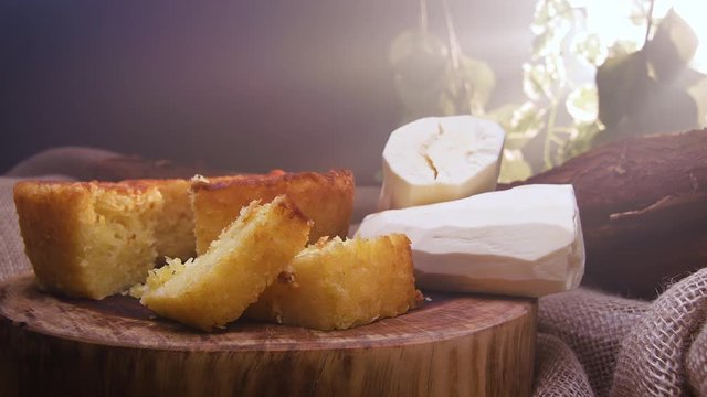 Cassava cake with a cut piece and cassava in the background