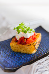 grilled polenta with tomato sauce and cheese and sprouts