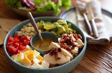Homemade cobb salad on a rustic wood surface