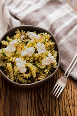 Pasta salad with zucchini and pesto dressing and white cheese