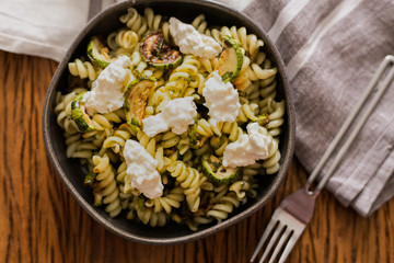 Pasta salad with zucchini and pesto dressing and white cheese