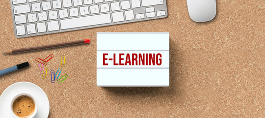 lightbox with message e-learning and office equipment on cork background