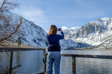 travel woman use smart phone o taking photo of the beautiful mountain landscape.