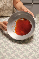 Verter y esparcir caramelo liquido en molde para pastel