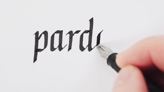 Handwritten word Pardon. Male hands writing with a pen. Calligraphy closeup.