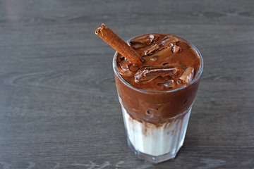 Ice cocoa drink with cinnamon On wood table.