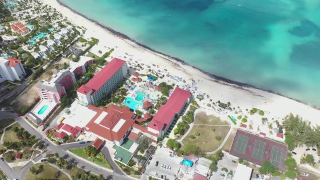 Bahamas, Nassau, Cinematic Aerial View of White Sand Beach, Hotels and Resort on Waterfront of Exotic Island