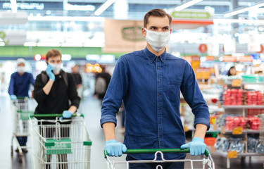young man in a protective mask with a shopping cart