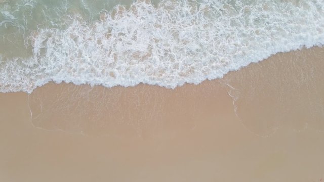 Aerial view top view Beautiful topical beach with white sand. Top view empty and clean beach. Waves crashing empty beach from above. 