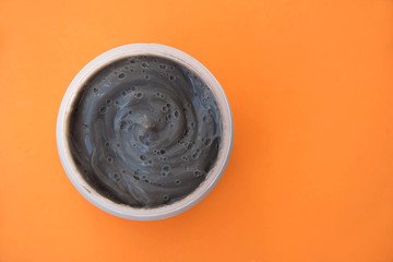 cream face mask gray orange background top view, skin care