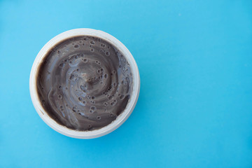 cream face mask gray blue background top view, skin care