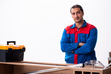 Young handsome male carpenter working indoors