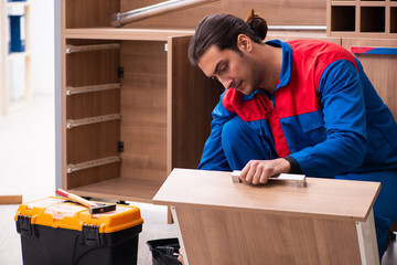 Young handsome male carpenter working indoors