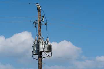 Wooden electric power pylon on a sunny spring day.
