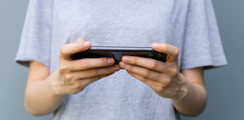 Closeup of young woman hand holding smartphone and chatting with friends at social network.