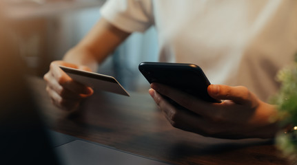 Woman hand using smartphone and holding credit card with payment online on mobile.