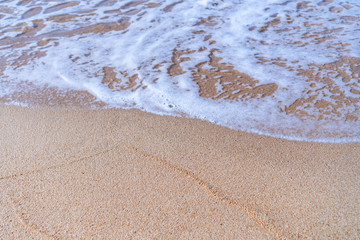 Top view of sand and water clean beach and white sand in summer with sun light blue sky and bokeh background.