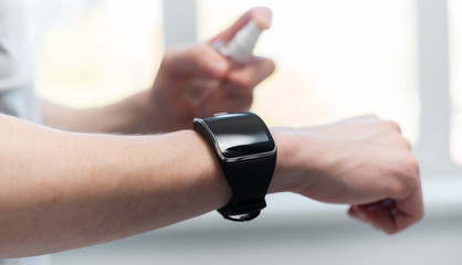 close up. young man decontaminating his smartwatch.