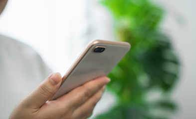 Close-up of hand holding smartphone device and typing text message on online social.