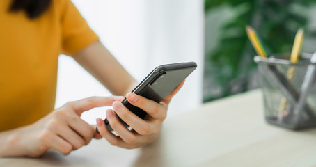 Close-up of hand holding smartphone device and typing text message on online social.