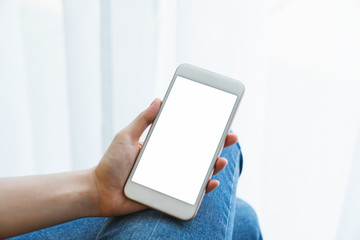 Mock up of woman hand holding smartphone and touching blank screen.