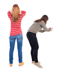 Back view of two young woman photographed on a mobile phone in sweater.