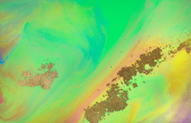 Fototapeta na wymiar Golden dust and green background. Sparkling gold texture.
