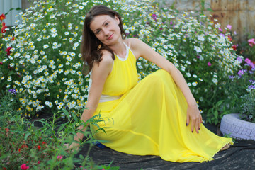 girl in a yellow dress is photographed in flowers
