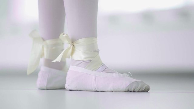 Girl dancer feet in ballet shoes walk ambulate on her toes