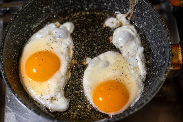 Cooking scrambled eggs on an old dirty frying pan