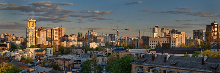 construction cranes on the evening cityscape background