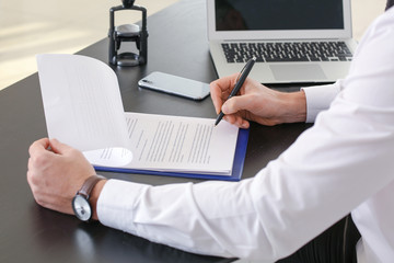 Male lawyer working with document in office, closeup