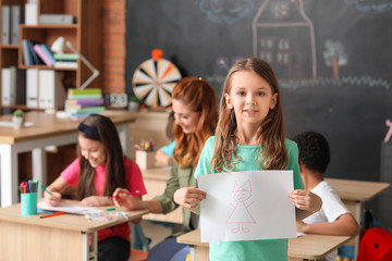 Cute girl with drawing at school