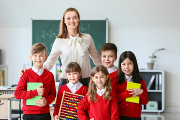 Children with math teacher during lesson in classroom